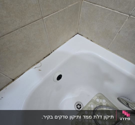 תקריב של פינת אמבטיה לבנה וקיר אריחי קרמיקה